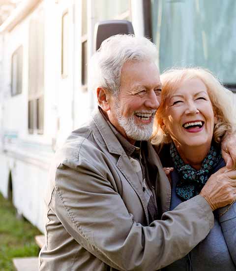 Älteres Ehhepaar freut sich über ihr Wohnmobil
